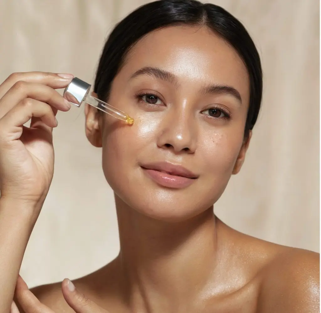 woman applying serum to skin