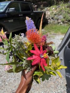 black woman's hand holding colorful flowers