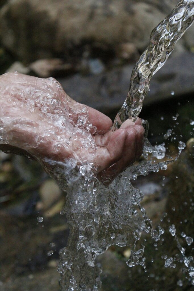 SonderBeaut hand grasping at running water