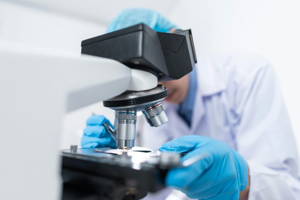 scientist observing a specimen under the microscope