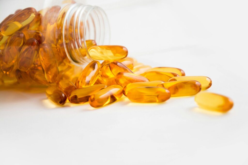 orange supplements spilling from a vitamin bottle