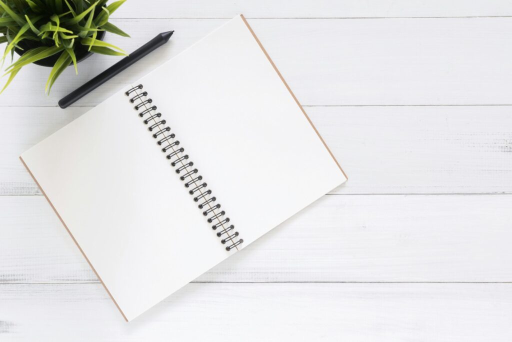 SonderBeaut pencil and notebook near a plant