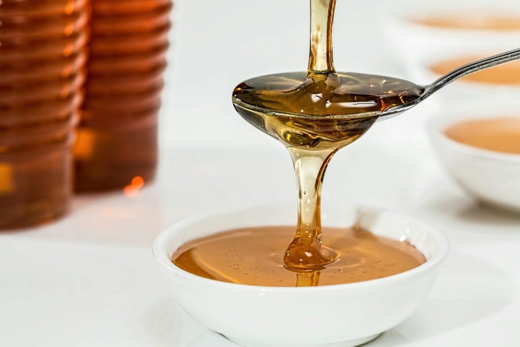 SonderBeaut honey poured onto spoon and dripping from spoon to cup