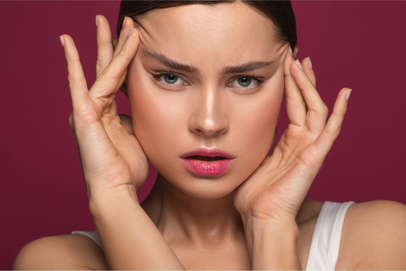 woman pulling up skin by the cheeks