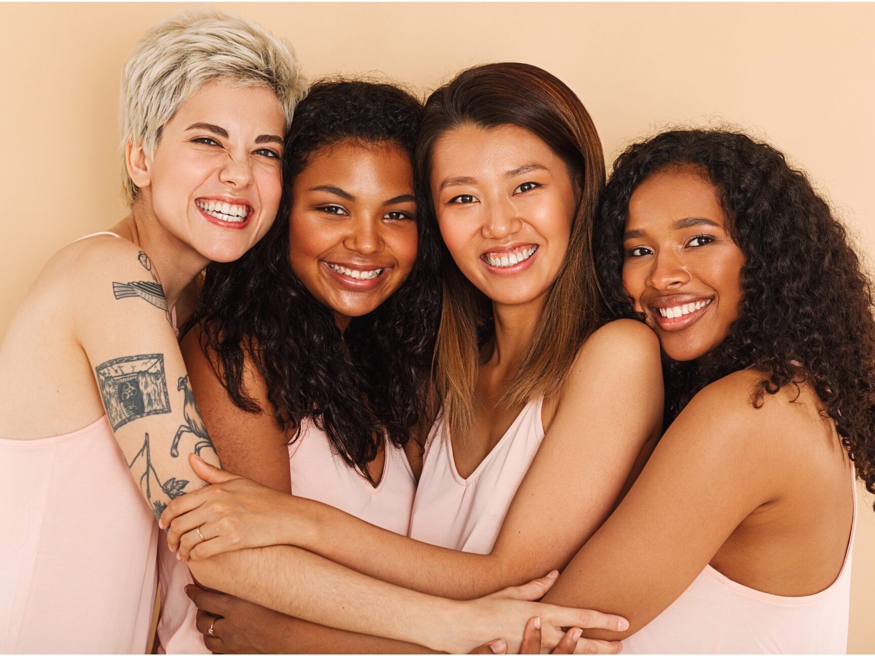 diverse women embracing looking at the camera