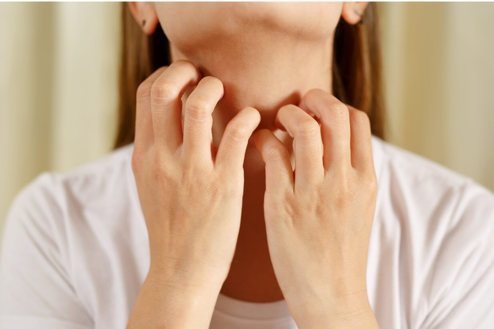 woman itching neck from allergic reaction