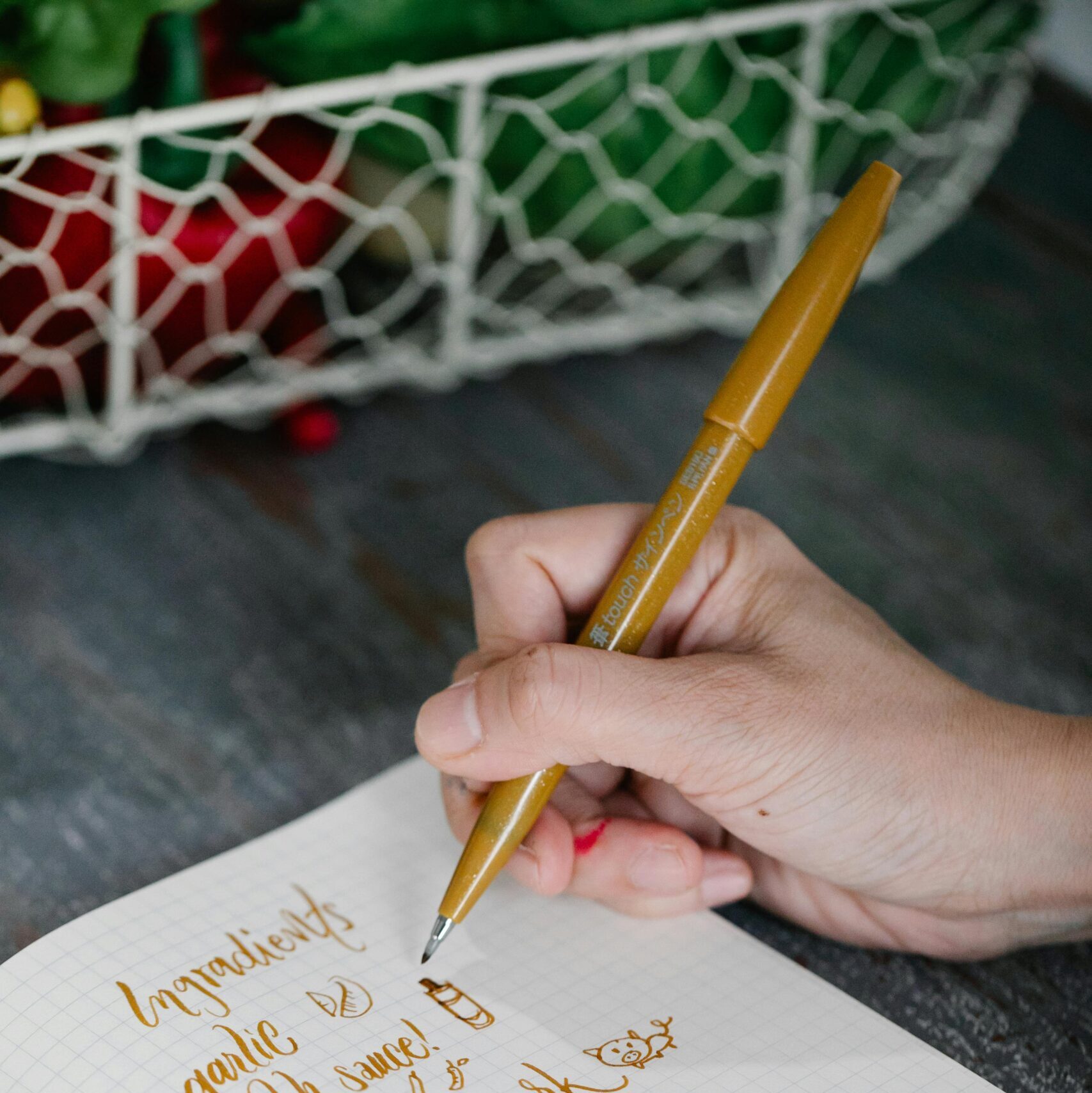 white male's hand writing an ingredient list